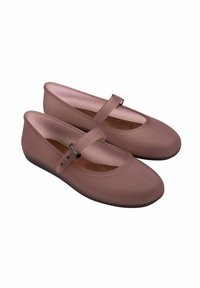 Bailarinas de goma rosa con punta redondeada, correa al tobillo y un acabado mate suave. Presentan una plantilla acolchada y un sutil diseño texturizado.