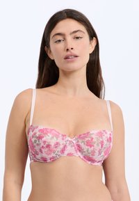 Soutien-gorge balconnet en dentelle avec un motif floral rose et gris, dotée de panneaux transparents, d'un tissu doux et de bretelles transparentes réglables.