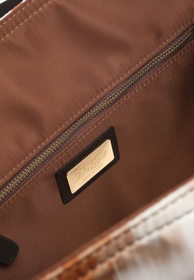 Brown fabric interior of a bag with a horizontal zipper pocket and a gold brand label reading "Luisa Spagnoli, Made in Italy."