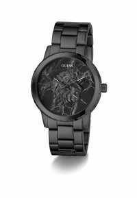 Ceas negru cu un relief de leu pe un cadran cu model de marmură, având o brățară metalică și numele brandului „GUESS” afisat deasupra cadranului.