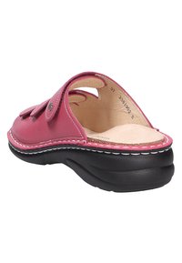 Pink leather sandal with cut-out design, a beige cushioned insole, and a black rubber sole. Features white stitching along the edge.