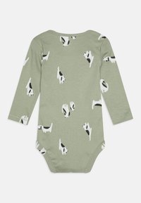Long-sleeve onesie in soft light green fabric, featuring a playful pattern of black and white dogs, with a round neck and snap closure.