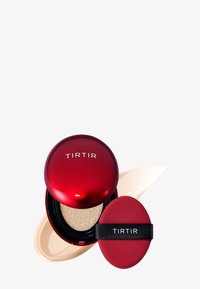 Rond rood compact met het label "TIRTIR," met een spons erin. Beigekleurige crème ernaast geswirld, die een gladde textuur benadrukt.
