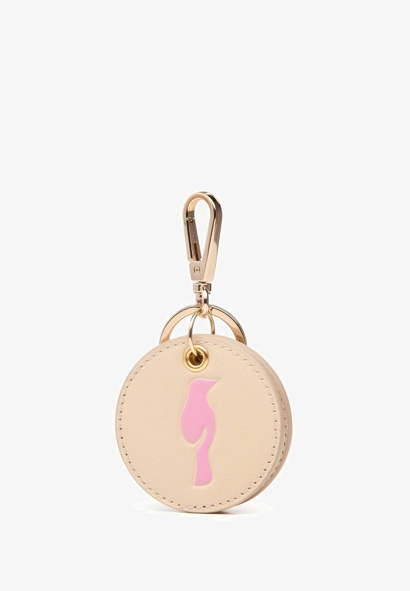 Okrągła beżowa skórzana zawieszka na klucze z złotym klipsem, ozdobiona różowym konturem ptaka i złotymi pierścieniami. Gładka tekstura z kontrastującymi kolorami.