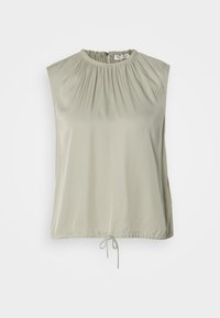 Blouse sans manches beige clair avec encolure et ourlet froncés, détail noué en bas et fermeture par bouton au dos.