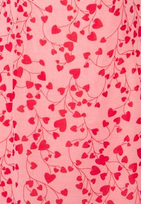 Pink fabric with a repeated pattern of red hearts connected by slender vines, creating a soft, textured appearance.