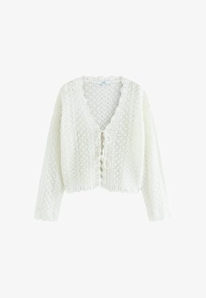 Balta adīta kardigāna ar V-veida kaklu, atvērta priekšpuse ar sasienamu aizdari, viļņotu apakšmalu un teksturētu dimanta rakstu visā virsmā.