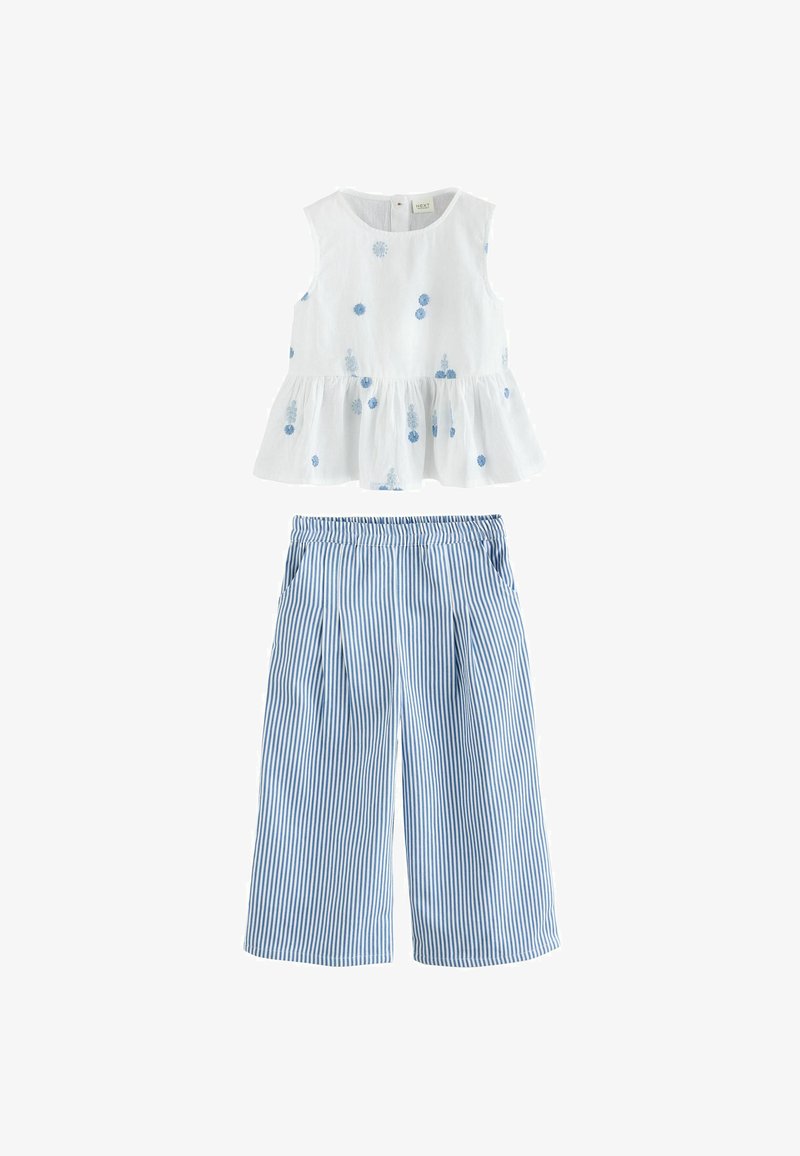 White sleeveless top with blue floral embroidery and peplum hem paired with blue and white vertical striped wide-leg pants.