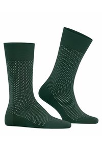 Grüne Socken mit einem gerippten Bündchen, das ein gepunktetes Muster aufweist. Sie bestehen aus einem glatten Stoff und haben ein verstärktes Material an Zehen und Ferse.