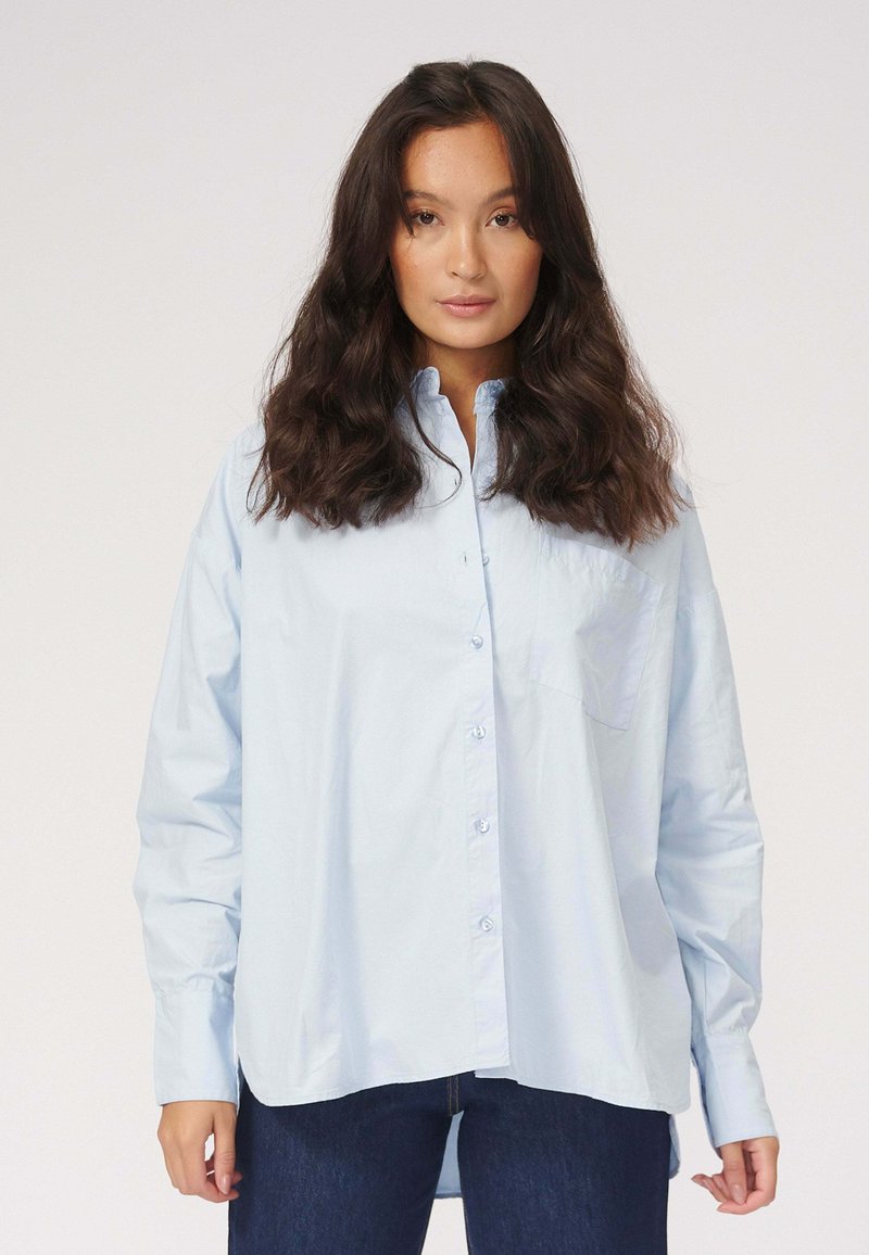 Lyseblå button-up skjorte lavet af bomuld, med pointet krave, lange ærmer, en brystlomme og en afslappet pasform.