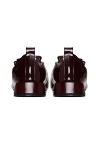 Chaussures en cuir verni bordeaux avec un petit talon bloc, un dos arrondi et des coutures décoratives, dotées de petites languettes à l'arrière pour un enfilage facile.