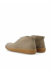 Beżowe zamszowe buty w stylu mid-top z okrągłym noskiem, subtelnymi detalami przeszycia i gumową podeszwą. Miękka tekstura cholewki o minimalistycznym wzornictwie.