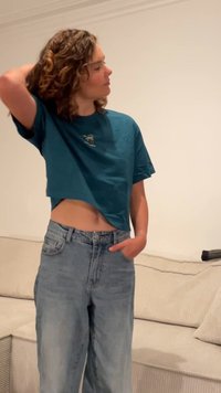 Teal kortermet t-skjorte med palmestammegrafikk, kombinert med høytlivs lyseblå denimjeans. Myk tekstur, uformell passform.
