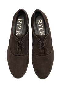Pantofi din suede maro, cu șireturi, având vârful rotunjit și o textură fină. Prezintă o branț cu marcă și șireturi tonale. Concepuți pentru purtare casuală sau formală.