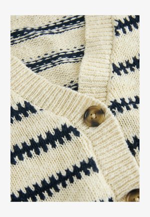 Sweter dziergany w odcieniu kremowym z granatowymi paskami. Charakteryzuje się dekoltem w kształcie litery V oraz zapięciem na guziki, miękką fakturą i widocznymi detalami ściągacza.