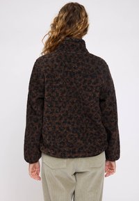 Braun und schwarzer Leopardenmuster-Fleece-Jacke mit hohem Kragen und lockerer Passform. Der Stoff ist weich und flauschig und hat lange Ärmel.
