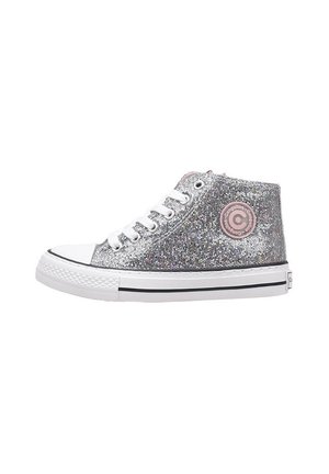 Zapatillas altas plateadas con un exterior brillante, punta de goma blanca y una franja negra alrededor de la suela. Presentan un logo circular rosa.