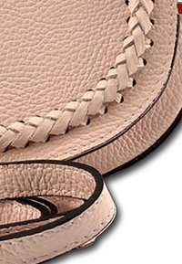 Lichtroze leren tas met een onderscheidende geweven rand en zwarte accenten. Geverfde textuur en een ronde vorm met een band.