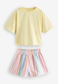 Gelbes Baumwoll-T-Shirt mit kurzen Ärmeln, kombiniert mit gestreiften Shorts mit elastischem Bund in Pastellfarben von Rosa, Blau und Gelb.