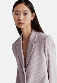 Lavender corduroy blazer met notch lapels, enkele knopen sluiten, en verticale ribbeltextuur. Bevat een diep V-halsontwerp.