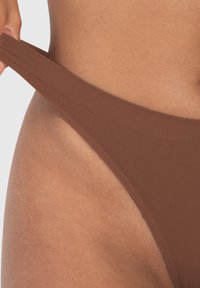 Bruine bikini onderkant gemaakt van gladde stof met een brede tailleband en minimale bedekking. De textuur is glad en rekbaar.