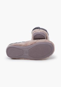 Zapatilla gris de felpa con un suave forro beige y suela de goma texturizada. La suela presenta estrías para mayor tracción y un respaldo redondeado para mayor comodidad.