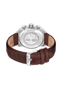 Hnedý kožený remienok hodiniek so strieborným púzdrom z nehrdzavejúcej ocele. Na zadnej strane je logo stromu a textúrované nastaviteľné zapínanie na pracku.