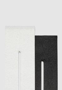 Dwa zestawy legginsów: jedne białe z delikatną teksturą, a drugie czarne z subtelnym błyszczącym wykończeniem. Oba mają elastyczny pas.