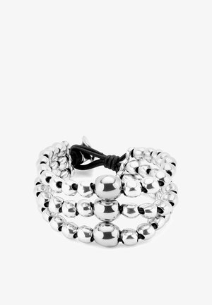 Bracciale con perline argentate composto da perle sferiche lucide di varie dimensioni, collegate da un cordoncino nero, che presenta un design a strati.