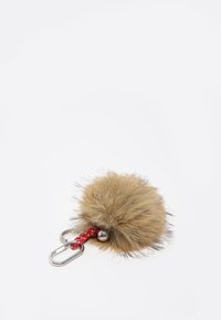 Llave de piel sintética en marrón claro con un pompón esponjoso, cordón trenzado rojo y mosquetón plateado, que cuenta con una pequeña campanita decorativa.