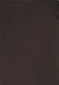 Černé látkové kalhoty s hladkou texturou, klasického střihu a jemným prošíváním podél švů.