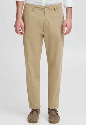 Beige katoenen broek met een recht-pasvorm, voorzien van een knoopsluiting, ceintuurlussen en minimale stikseldetails. Gladde textuur.