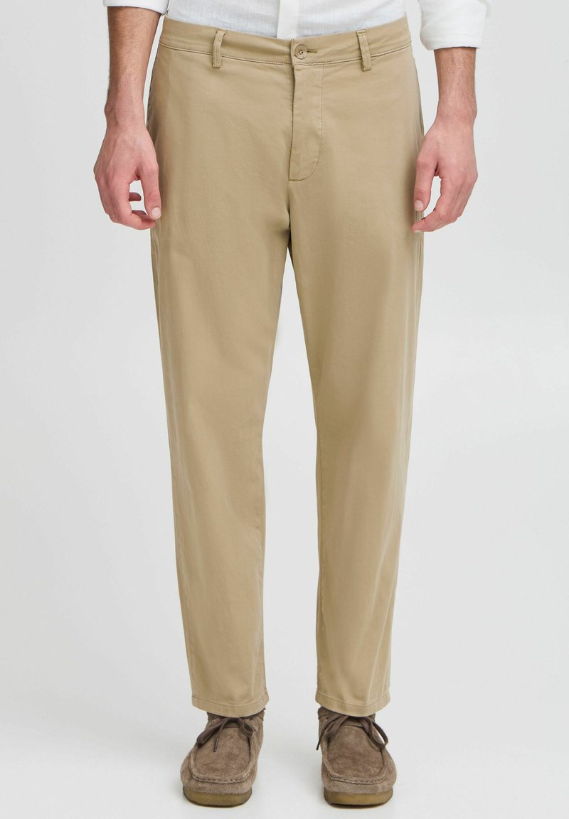 Beige katoenen broek met een recht-pasvorm, voorzien van een knoopsluiting, ceintuurlussen en minimale stikseldetails. Gladde textuur.