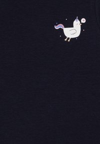 Marineblå bomulls T-skjorte med et hvitt unicornmotiv med rosa manke, gyldne detaljer og små fargerike stjerner og en hjerteboble.