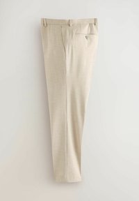 Pantalon de costume beige sur mesure avec passants de ceinture, poches latérales et une poche arrière boutonnée, suspendu sur un fond uni.