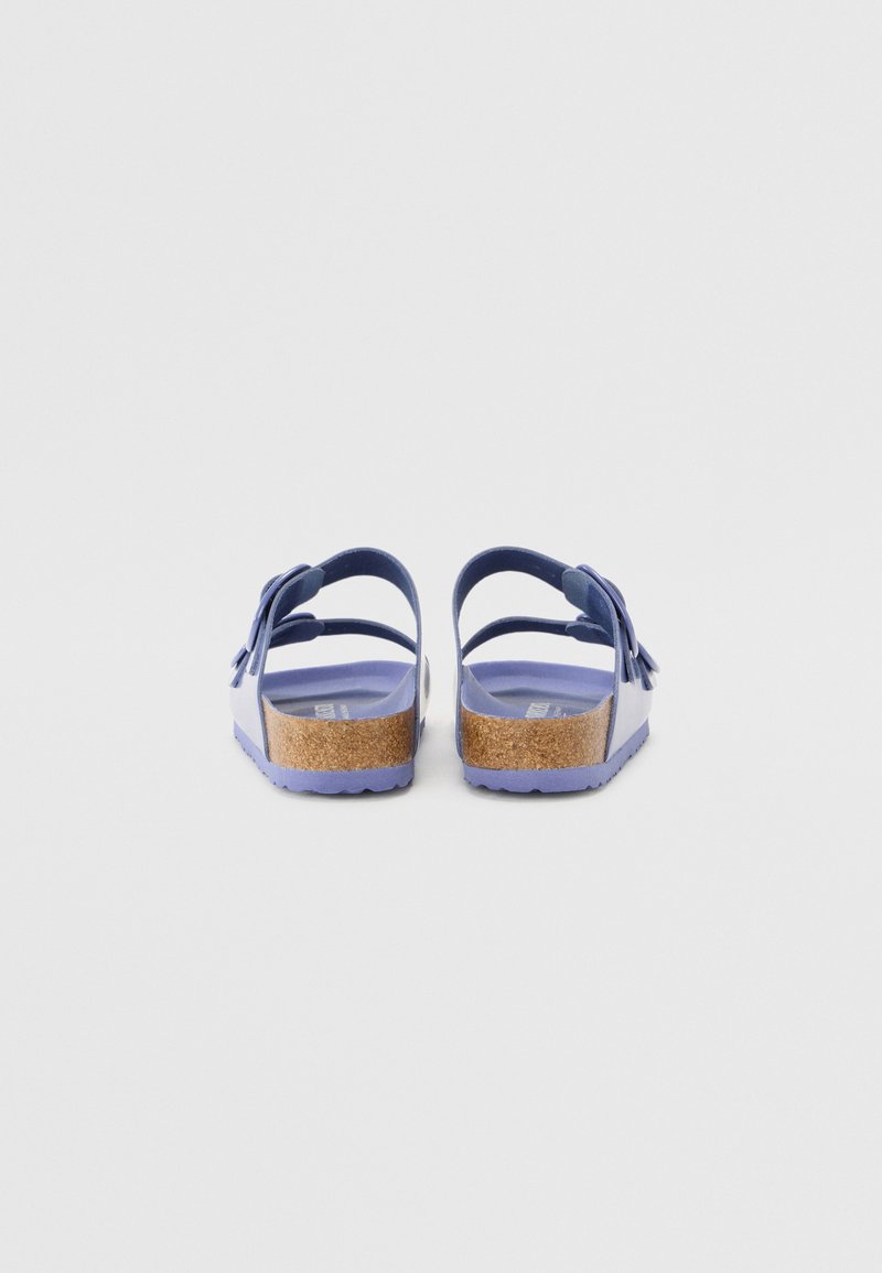 Lila Sandalen mit Korkfußbett, verstellbaren Riemen und Schleifchen auf der Rückseite, ausgestattet mit einer strukturierten Sohle und glatter Oberflächenfinish.
