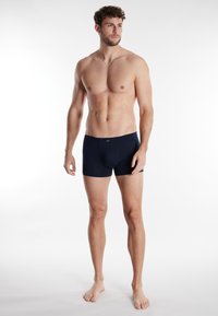 Marineblauwe herenboxers in een rekbare stof, met een zachte elastische tailleband en een aansluitend ontwerp voor comfort en ondersteuning.