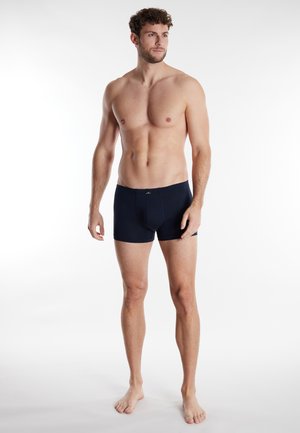 Marineblaue Herren-Boxershorts aus einem dehnbaren Stoff, mit einem weichen, elastischen Bund und einer taillierten Passform für Komfort und Halt.
