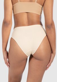 Mutandine beige a coste ad alta vita con un ampio elastico in vita, texture liscia e design minimalista. Vista da dietro.
