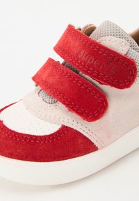Red and gray children's sneaker with suede and mesh materials, double Velcro straps, and perforated detailing on toe box.