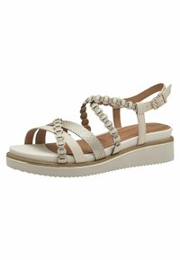 Helle beige Sandalen mit Kreuzriemen, einem strukturierten Akzentriemen, einer gepolsterten Innensohle und einer Keilsohle mit gezahntem Rand.