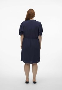 Vestido azul marino con mangas cortas en capas, una cintura ajustada, dobladillo a la altura de la rodilla y tela texturizada. La vista trasera muestra un escote redondo.