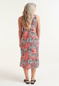 Vestido de lino rosa sin mangas con estampado de cebra negro. Longitud a mitad de pantorrilla, corte relajado, con dobladillo recto y un detalle mínimo.