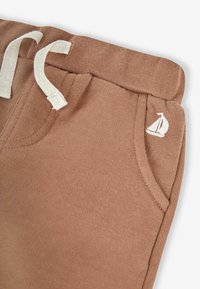 Ruske puuvillased üldpüksid elastse vöökoha ja valgete nööridega. Taskul on broderi tehnikas väike purjekas. Pehme tekstuur.