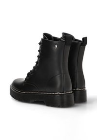 Botas de cuero negro con cordones y suela gruesa, con textura suave, hardware plateado y costuras en contraste a lo largo de la base.