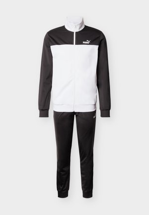 Trening Puma alb-negru cu jachetă cu fermoar și pantaloni asortați, având logo pe piept și coapsă.