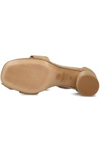 Beige suède hoge hak met een gestructureerde zool en een ronde neus. Heeft een lage, stevige hak en het merkembleem is op het voetbed gedrukt.