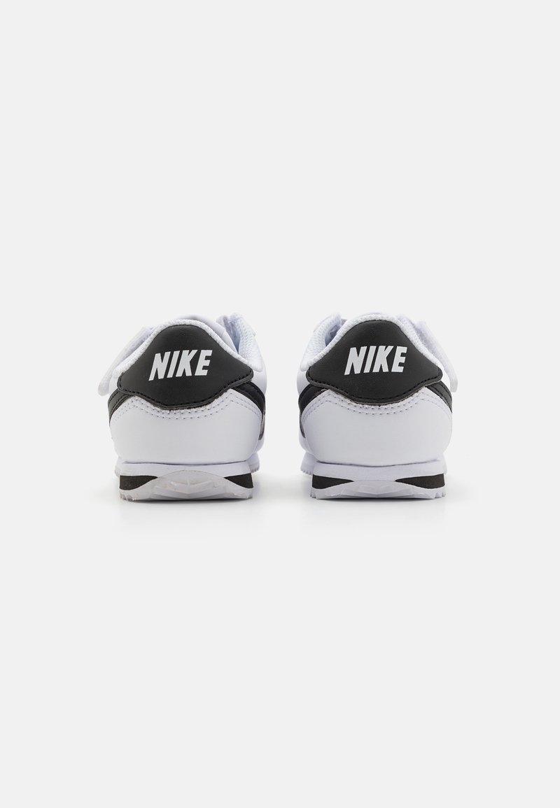 Zapatillas Nike en blanco y negro, con una parte superior de sintético suave, un collar acolchado y logotipos destacados en el talón.