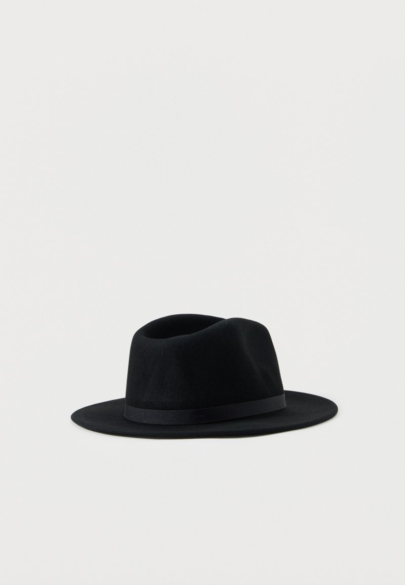 Μαύρο φελτ καπέλο φεντόρα με φαρδύ γείσο και μαύρη κορδέλα, σε απλό ανοιχτό γκρι φόντο.