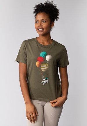 Khaki katoenen t-shirt met een astronaut die kleurrijke planetenballonnen vasthoudt. Het ontwerp bevat rode, groene, blauwe en gele sferen. Korte mouwen.
